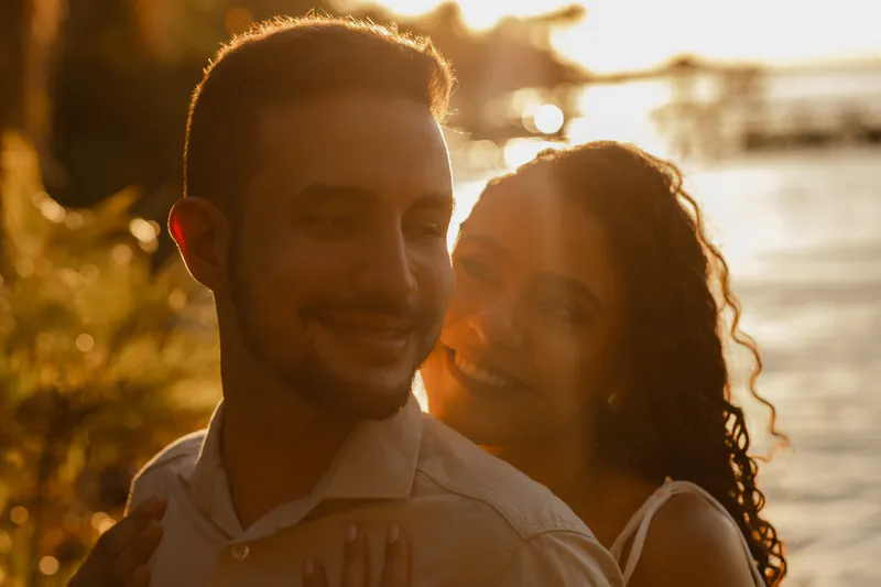 Casal sorrindo junto na luz do fim de tarde